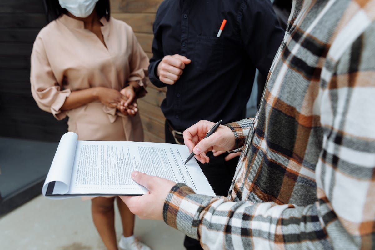 Three people in an office reviewing and signing a document together